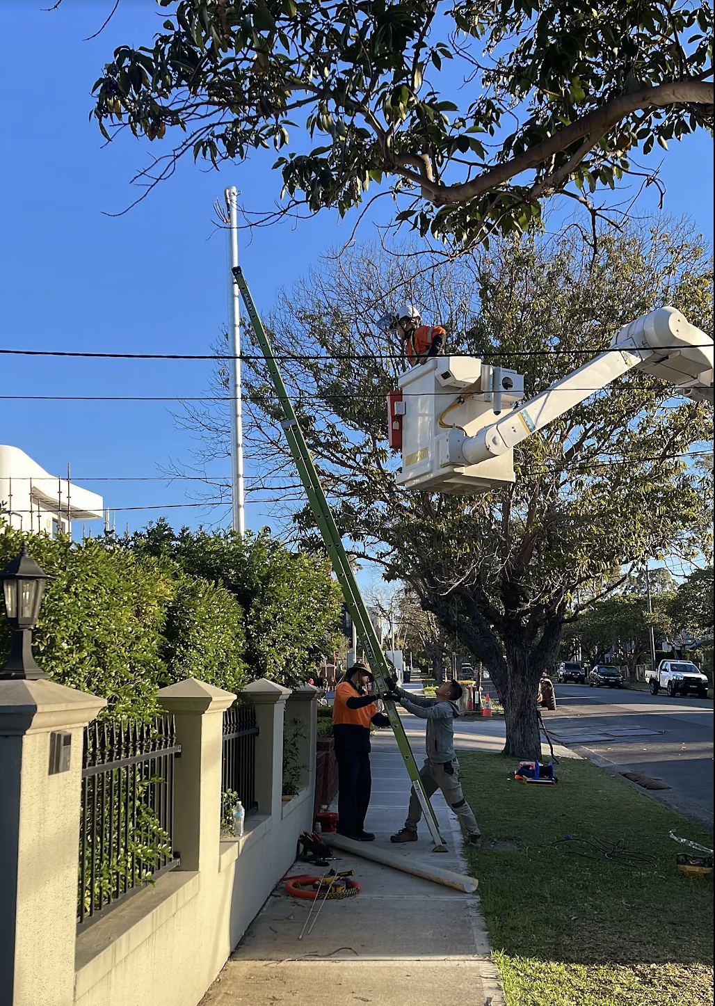 Bucket truck and crew installing a private pole on a residential street